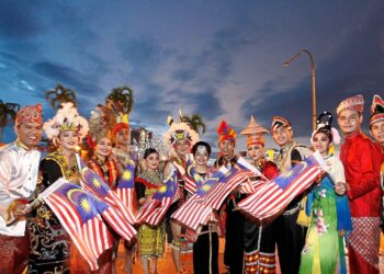 Patriotic spirit: Multiracial with traditional costumes waving flags at Dataran Sibu on Saturday night during Malaysia Day celebration. Photo: ZULAZHAR SHEBLEE / The Star