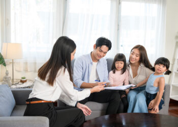 An Asian family meeting with female real estate agent or insurance consultant offering promotions , Mortgage, loan, property and medical health insurance concept.
