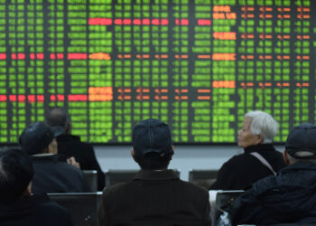 Investors sit in front of a board showing stock information at a brokerage house on the first day of trade in China since the Lunar New Year, in Hangzhou, Zhejiang province, China February 3, 2020. China Daily via REUTERS/Files