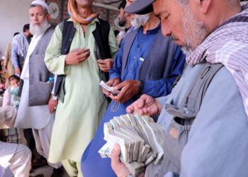 FILE PHOTO: Afghan money exchange dealers wait for customers at a money exchange market, following banks and markets reopening after the Taliban took over in Kabul, Afghanistan, September 4, 2021. REUTERS/Stringer/File Photo