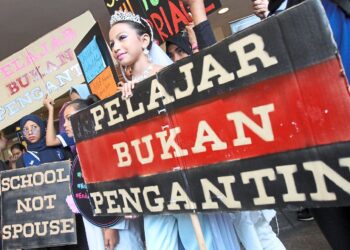 Protesters of child marriage at the "Walk the Talk to End Child Marriage" rally organised by women's groups hold up signs during the rally yesterday.