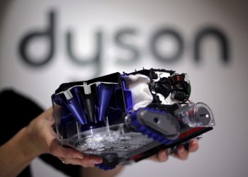 FILE PHOTO: A Dyson employee shows a Dyson 360 Eye robot vacuum cleaner without its cover during the IFA Electronics show in Berlin September 4, 2014. REUTERS/Hannibal Hanschke