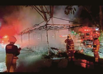 Anggota Bomba memadamkan kebakaran yang memusnahkan gerai mercun di Taman Pekaka turut tular di media sosial. - Foto JBPM