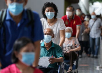 FILE PHOTO: People wait to receive coronavirus disease (COVID-19) vaccines at a vaccination centre in Kuala Lumpur, Malaysia May 31, 2021. REUTERS/Lim Huey Teng