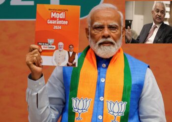 Indian Prime Minister Narendra Modi displays a copy of the ruling Bharatiya Janata Party's (BJP) election manifesto for the general election, in New Delhi, India, April 14, 2024. REUTERS/Adnan Abidi