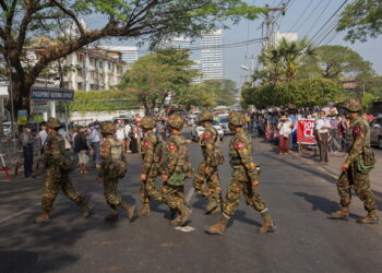 FILE PHOTO: Soldiers cross a street as people gather to protest against the military coup, in Yangon, Myanmar, February 15, 2021. REUTERS/Stringer