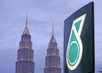 The logo of a Petronas fuel station is seen with the Petronas Twin Towers in the background in Kuala Lumpur, Malaysia. Picture taken February 10, 2016. REUTERS/Olivia Harris      TPX IMAGES OF THE DAY