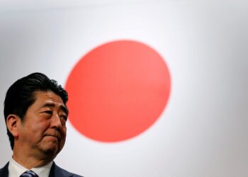FILE PHOTO: Japan's Prime Minister Shinzo Abe stands in front of Japan's national flag after his ruling Liberal Democratic Party's (LDP) annual party convention in Tokyo, Japan, March 5, 2017.  REUTERS/Toru Hanai