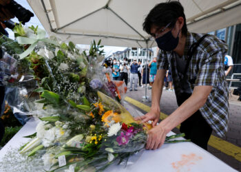 A man offers flowers at the site where late former Japanese Prime Minister Shinzo Abe was shot while campaigning for a parliamentary election, near Yamato-Saidaiji station in Nara, Japan, July 9, 2022. REUTERS/Issei Kato