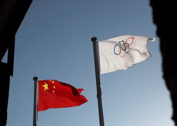 FILE PHOTO: The Chinese and Olympic flags flutter at the headquarters of the Beijing Organising Committee for the 2022 Olympic and Paralympic Winter Games in Beijing, China November 12, 2021. REUTERS/Thomas Suen