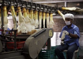 A worker monitors a production line at a Top Glove factory in Meru outside Kuala Lumpur June 25, 2009. REUTERS/Bazuki Muhammad (MALAYSIA BUSINESS SOCIETY HEALTH) - GM1E56P19DE01