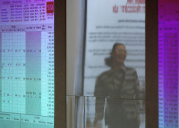 FILE PHOTO: An investor is seen reflected on stock market screens at a securities company in Hanoi, Vietnam, April 20, 2016. REUTERS/Kham