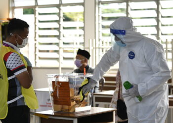 KLUANG, 12 Mac -- Seorang pekerja pembersihan melakukan sanitasi di peti undi pada Pilihan Raya Negeri (PRN) Johor ketika tinjauan di Pusat Mengundi Sekolah Agama Taman Sri Lambak hari ini.?
--fotoBERNAMA (2022) HAK CIPTA TERPELIHARA