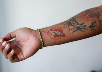 FILE PHOTO: Lin Lin Bo Bo, whose parents cut ties with him, shows his tattoo to mark the Myanmar Spring revolution, at Thai-Myanmar border, January 26, 2022. REUTERS/Soe Zeya Tun