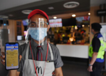 KUANTAN, 11 Ogos -- Pekerja restoran makanan segera Tengku Muizzuddin Tengku Anuar menunjukkan sijil digital vaksinasi menerusi applikasi MySejahtera ketika pegawai Polis Daerah Kuantan melakukan pemantauan pematuhan prosedur operasi standard (SOP) di Pusat Peranginan Teluk Cempedak hari ini.
Bagaimanapun restoran tersebut belum bersedia menerima pelanggan makan di kedai ekoran ancaman varian COVID-19 yang semakin meningkat di Pahang dan terdapat segelintir beberapa pekerja yang belum menerima suntikan vaksin COVID-19.
Pada Ahad lalu, Perdana Menteri Tan Sri Muhyiddin Yassin mengumumkan individu yang lengkap divaksinasi hanya perlu menunjukkan sijil digital vaksinasi sebelum dibenarkan menikmati makanan juga dan semua pekerja kedai perlu lengkap dua dos vaksin sebelum membuka kedai untuk tujuan 'dine-in'.
--fotoBERNAMA (2021) HAK CIPTA TERPELIHARA