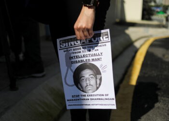 FILE PHOTO: An activist holds a poster against the execution of Nagaenthran Dharmalingam, a Malaysian whose intellect, his defence and human rights groups have argued, was at a level recognised as a mental disability, for drug trafficking in Singapore, as activists submit a clemency petition at the Singapore High Commission in Kuala Lumpur, Malaysia, March 9, 2022. REUTERS/Hasnoor Hussain