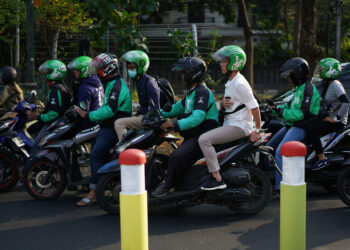 Go-Jek motorcycle taxi drivers and passengers sit in traffic in Jakarta, Indonesia, on Saturday, Aug. 4, 2018. Indonesia's gig economy is booming, yet there's a debate about whether that's necessarily a good thing for a big chunk of the nation's workforce or the overall economy in the long-run. Photographer: Dimas Ardian/Bloomberg