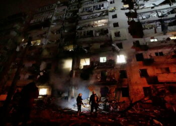 Firefighters work at the site of a damaged residential building, after Russia launched a massive military operation against Ukraine, in Kyiv, Ukraine, February 25, 2022 in this frame grab of a still image use in a video.  Ukrainian Ministry of Emergencies/via Reuters TV/Handout via REUTERS