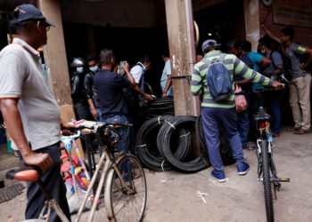 Customers wait outside a cycle shop to buy tires due to major fuel shortage, amid the country's economic crisis, in Colombo, Sri Lanka, July 6, 2022. REUTERS/Dinuka Liyanawatte