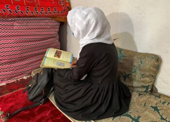 An Afghan schoolgirl reads from her book inside a house in Kabul, Afghanistan, March 23, 2022. REUTERS/Charlotte Greenfield