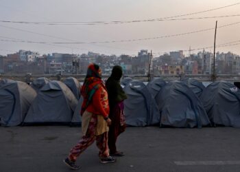 Women walk past rows of tents used by farmers who have gathered to protest against farm laws at Ghaziabad, India, January 28, 2021. REUTERS/Danish Siddiqui - RC22HL9VTEXI