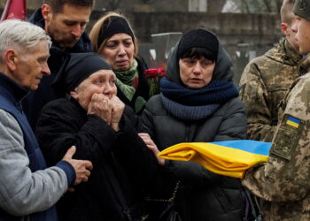 The mother of Senior Lieutenant Dmytro Oliinyk, 40, who was killed in battle amid Russia's attack on Ukraine, reacts before she is handed over a Ukrainian national flag, during a funeral ceremony at the Lychakiv cemetery, in Lviv, April 2, 2022. REUTERS/Alkis Konstantinidis